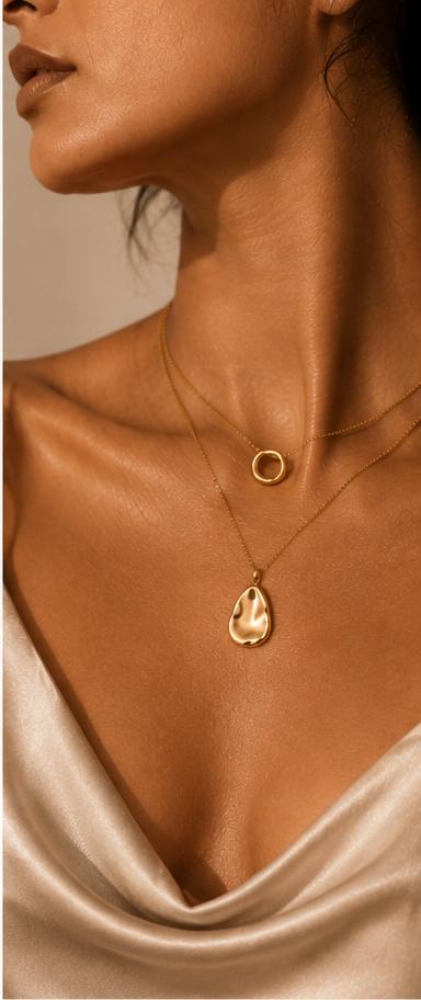 Layered gold necklaces worn at the neckline
