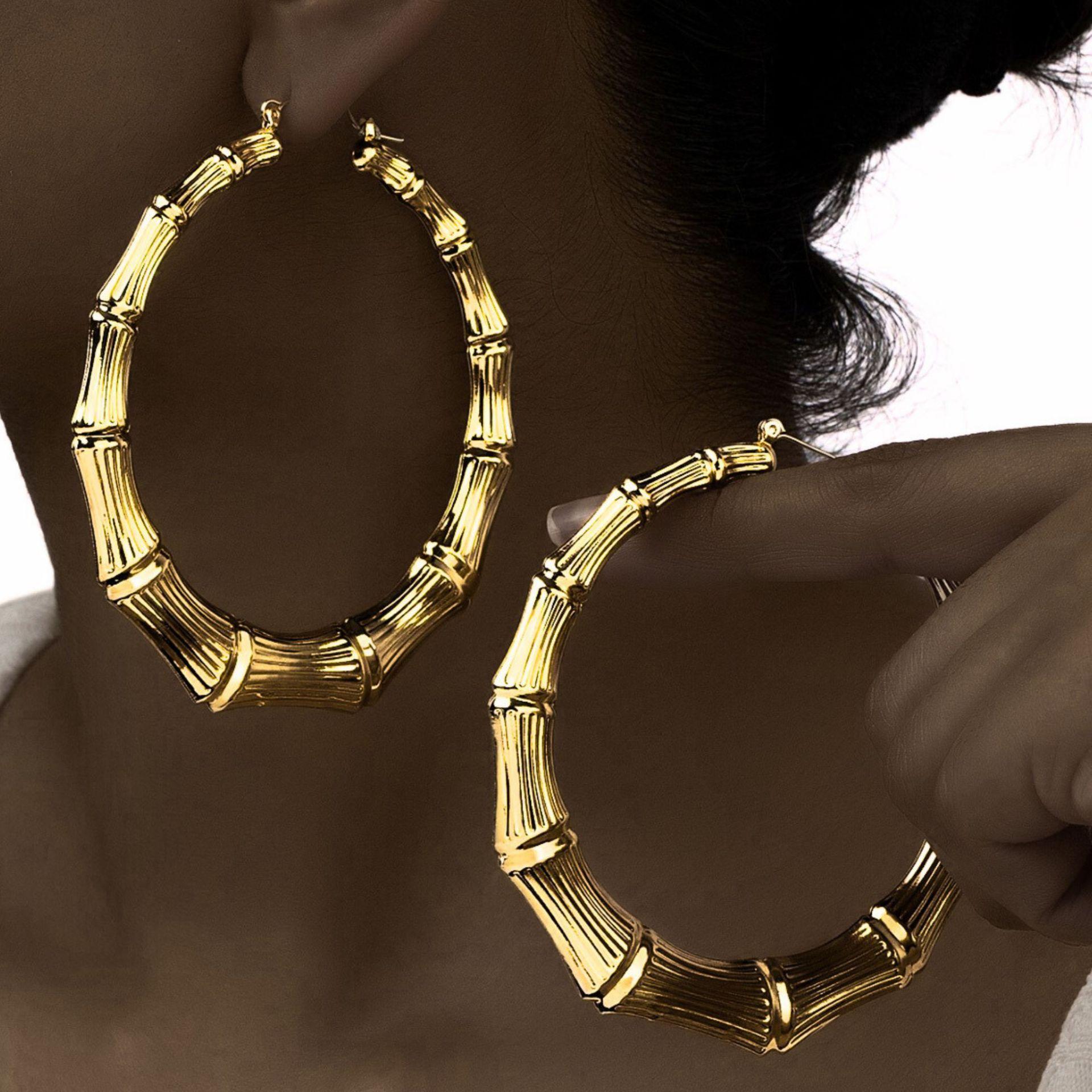 Woman wearing ZERVALIS gold bamboo hoop earrings